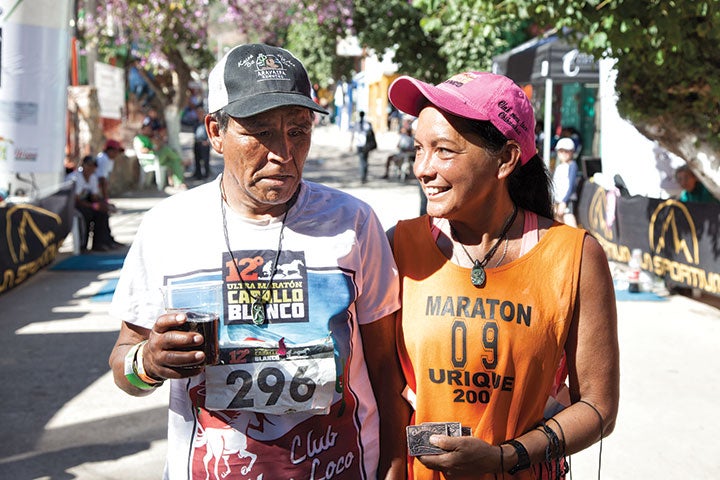 Two Tarahumarans approach the finish line in downtown Urique (top); Maria Walton (Micah True's significant other) greets a racer at the finish line.