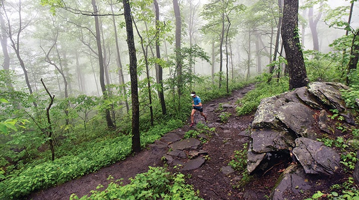 Scott Jurek running on a muddy section of the Appalachian Trail