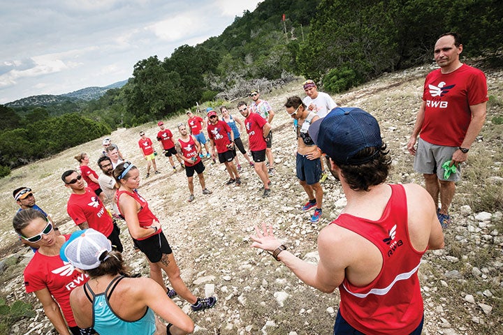 Just three months after the Team RWB trail-running camp, Chad Prichard smiles at an aid station midway through the Bandera 100K, his first ultra-distance trail race.