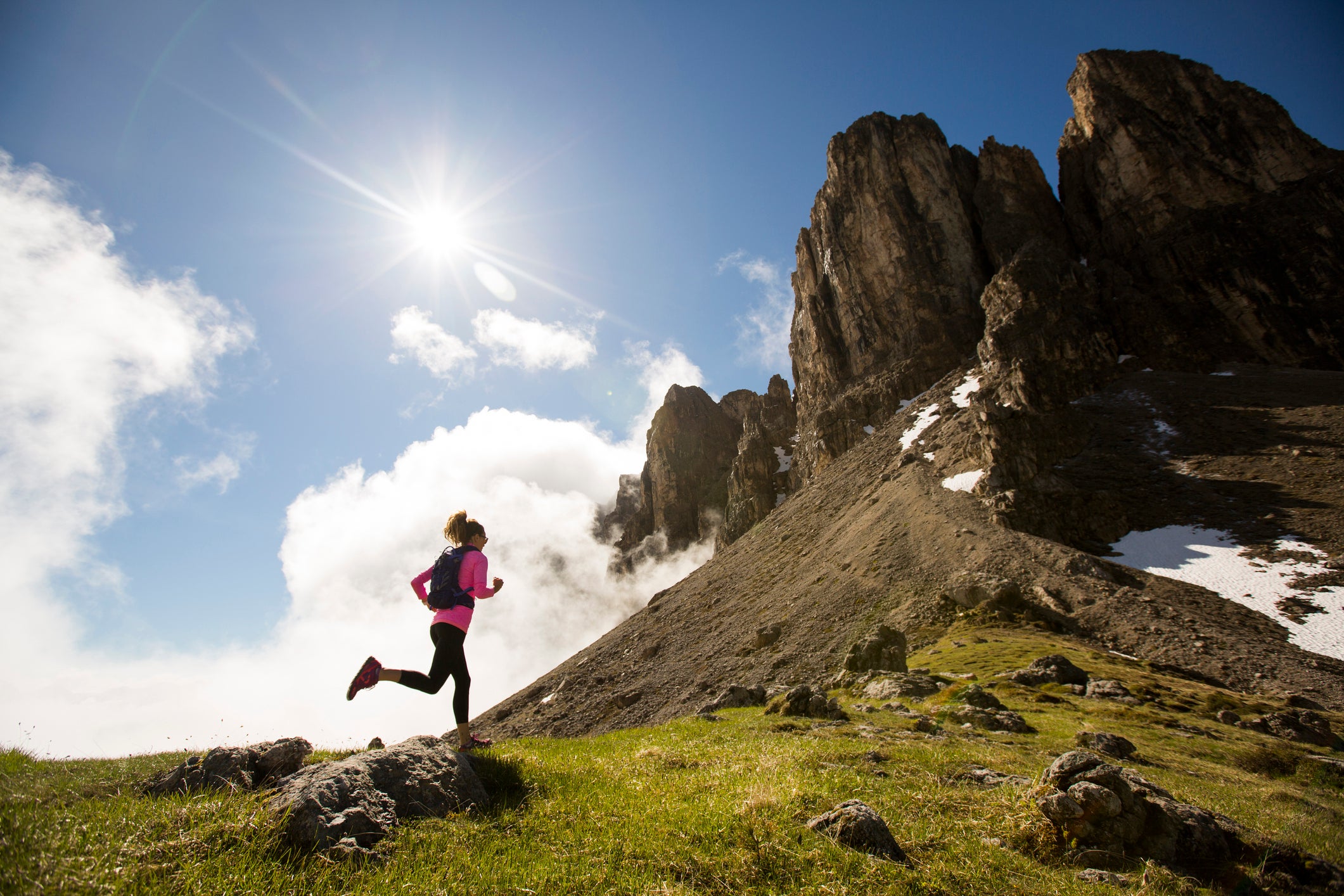 A female trail running in the Dolomite mountains of Italy.
