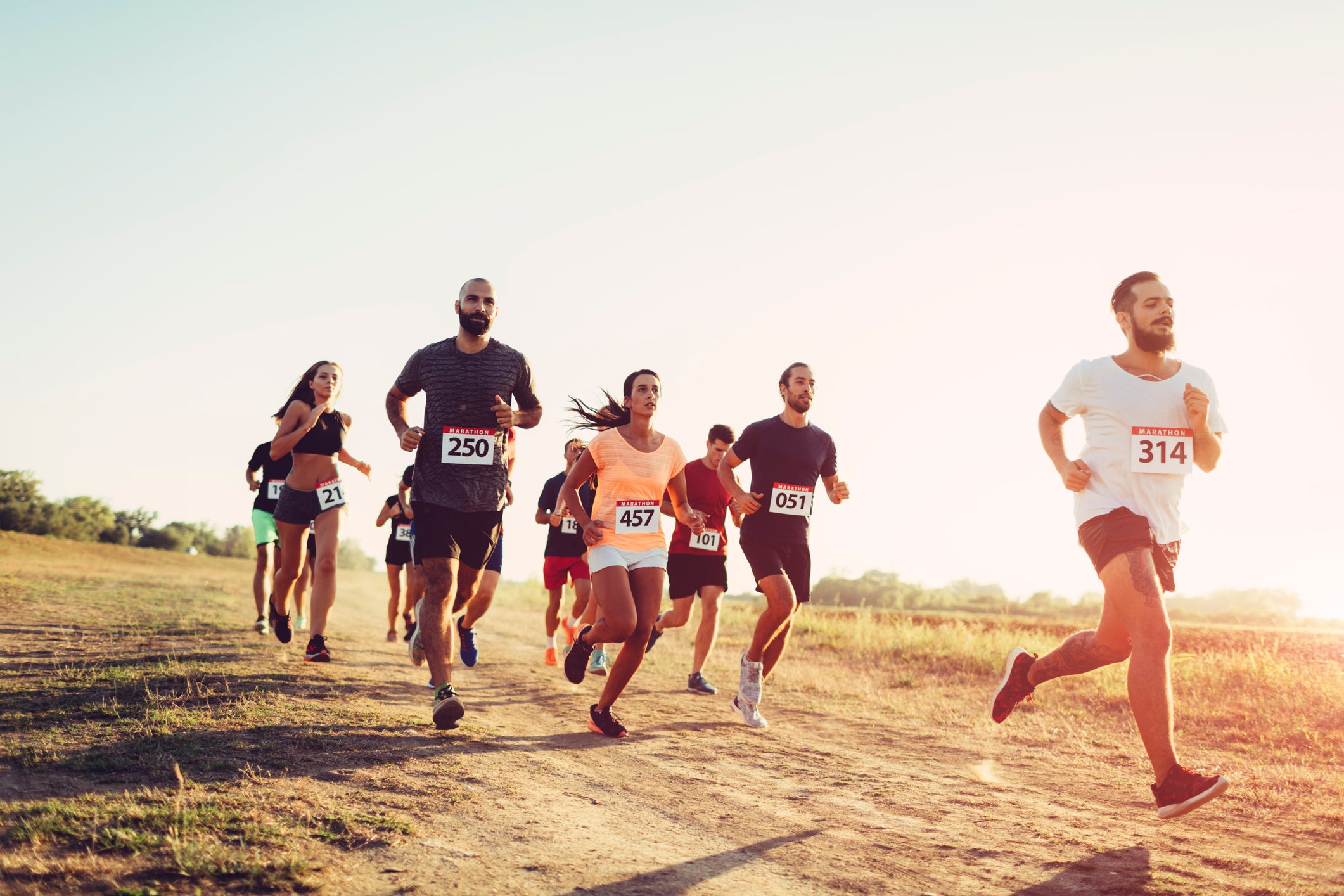 Group of friends running on marathon outdoors.