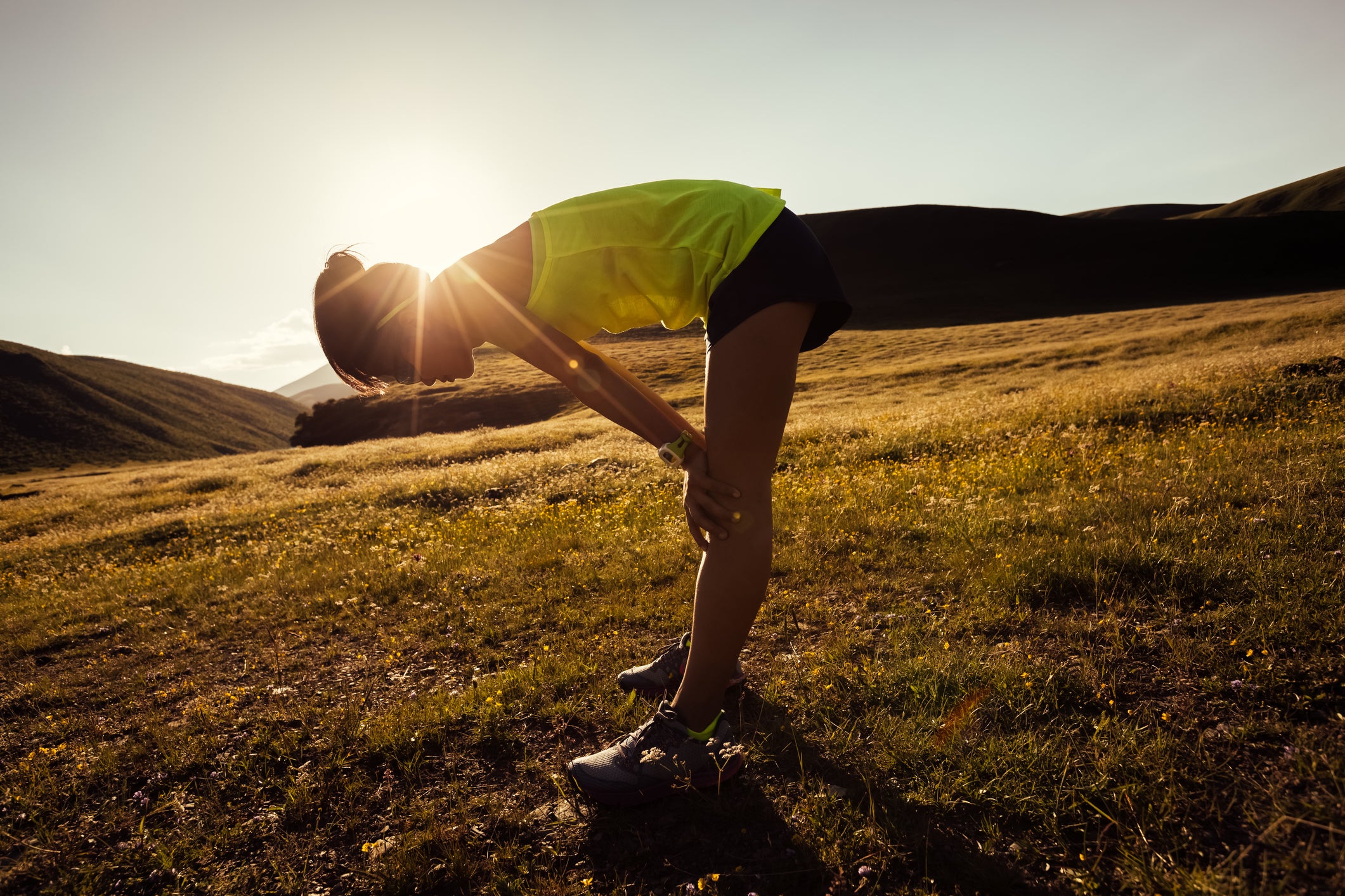 Young fitness woman trail runner have a rest on grassland