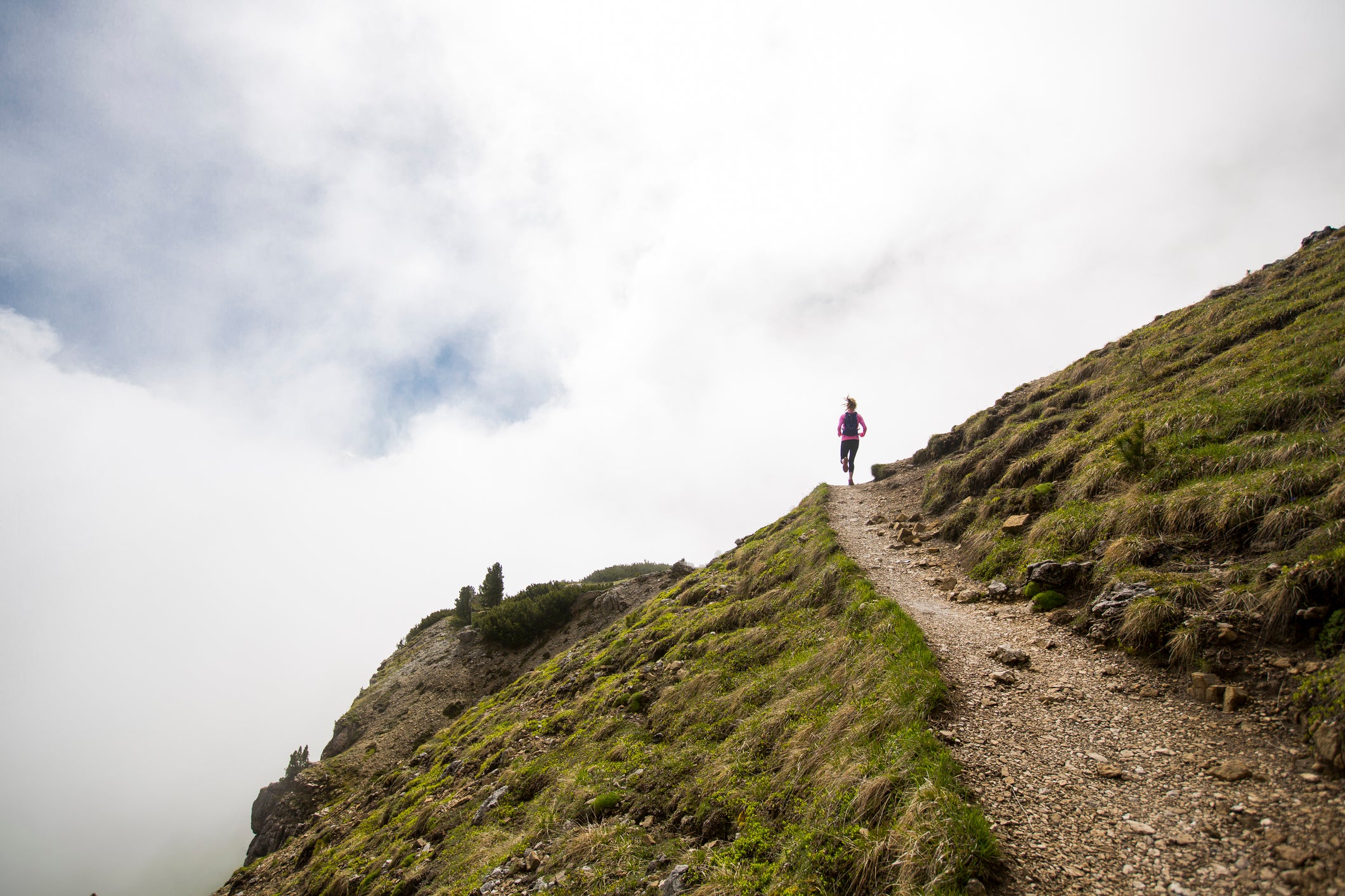 A female trail running in the Dolomite mountains of Italy.