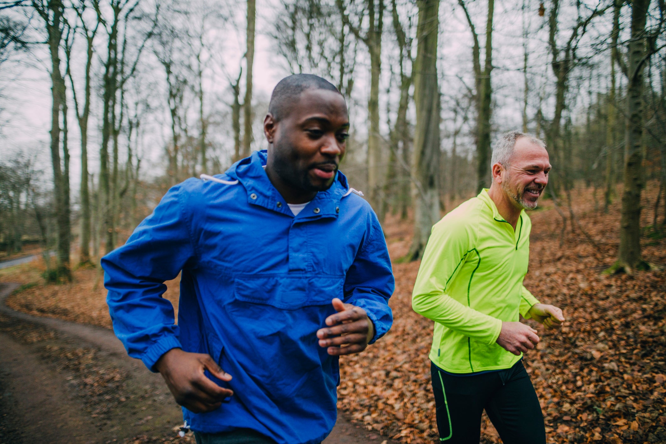 Two friends jogging up the trails in the forest to get fit.