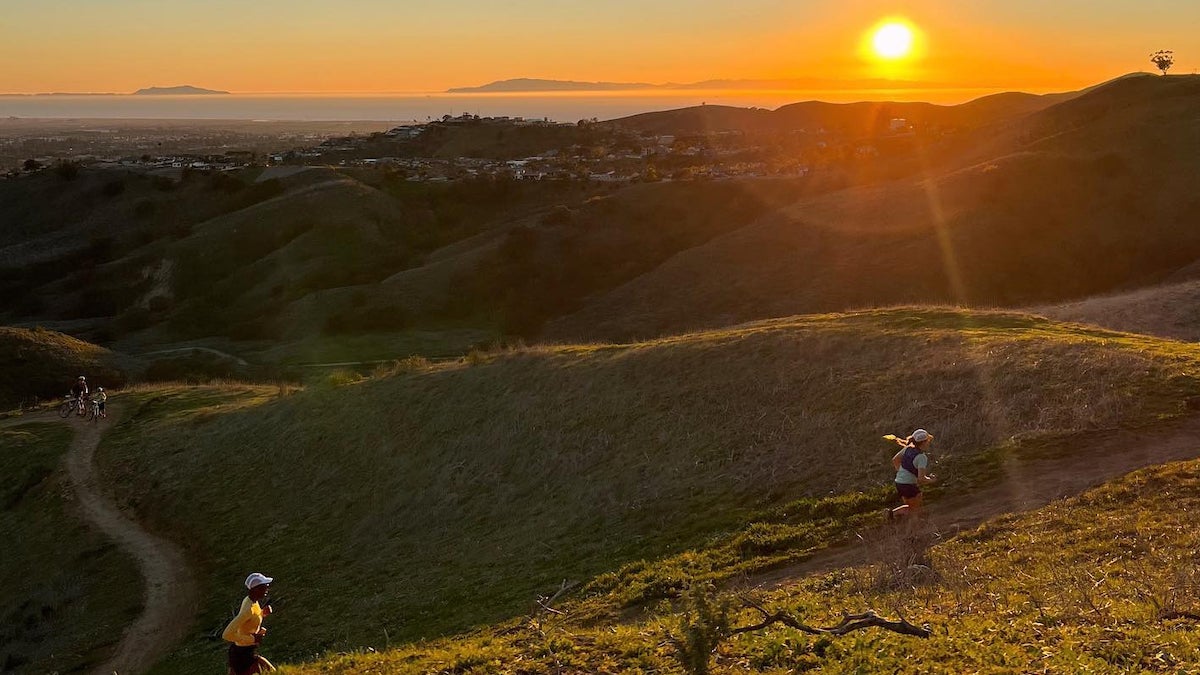 two trail runners at sunset